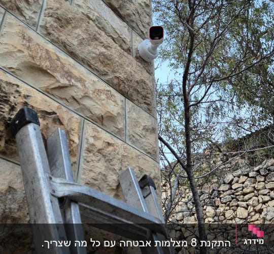מצלמת אבטחה מותקנת על קיר אבן חיצוני